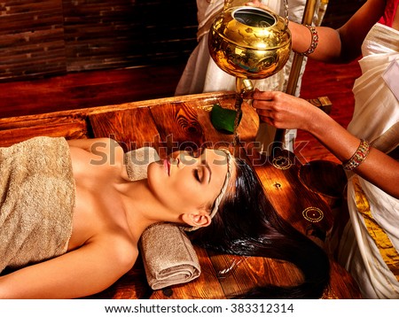 Young woman having oil head Ayurveda spa treatment. Royalty-Free Stock Photo #383312314