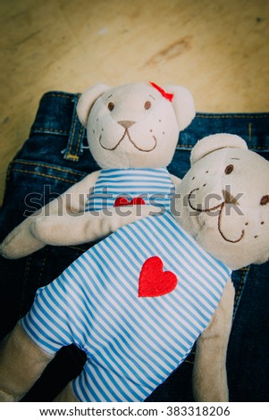 Teddy bear on jeans background. The picture concept is about of love. Vintage retouching.