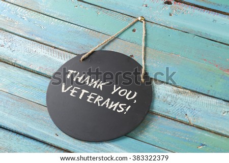 veterans day chalk sign on blue wood background with flag