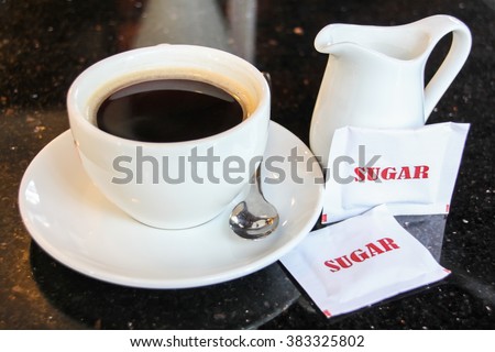 A cup of coffee, milk and sugar sachet for refreshing in the morning