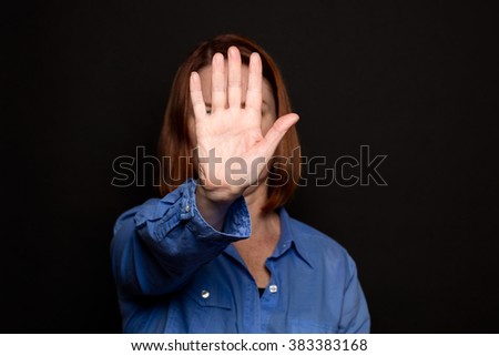 Woman holding hand in front of face - gesturing stop