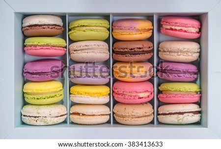 Set of different french cookies macaroons macaroons in a paper box. Top view. Coffee, chocolate, vanilla, lemon, raspberry, strawberry, pistachio, violet, rose, orange tastes macaroons
