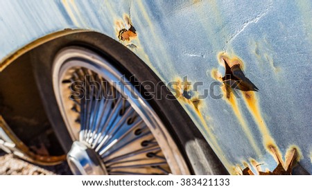 Old rusty leaky vintage car close up details with chrome hubcaps