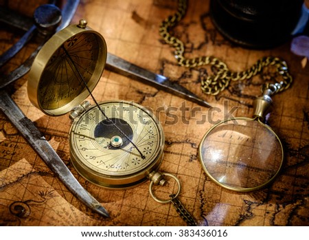 Old vintage retro compass, measuring devices and magnifying glass on ancient world map. Vintage still life. Travel geography navigation concept background.
