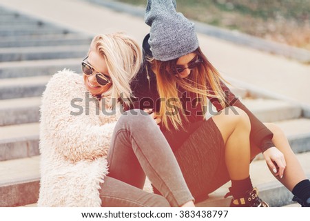 Outdoor lifestyle portrait of two best friends, smiling and having fun together, enjoy eachother company posing and makingselfie pictures to eachother and share happiness