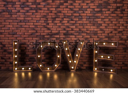 large wooden illuminated letters on the brick wall background