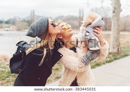 two young caucasian cute girls portrait with dog outdoor in park walking happy and smile all the way 