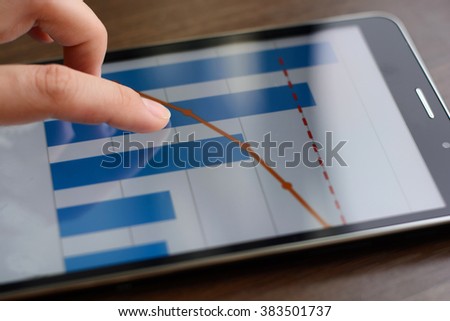 Female hands on a wooden office desk touch screen tablet with the image of a color chart