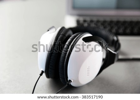 Headphones and laptop on table closeup