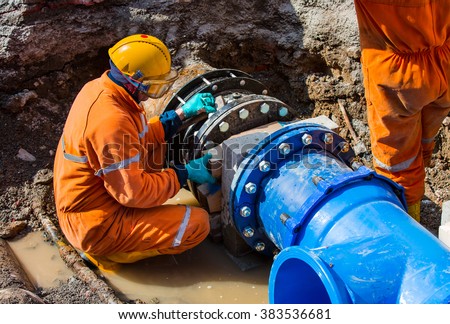 Old big drink water pipes joined with new blue valves and new blue joint members Royalty-Free Stock Photo #383536681