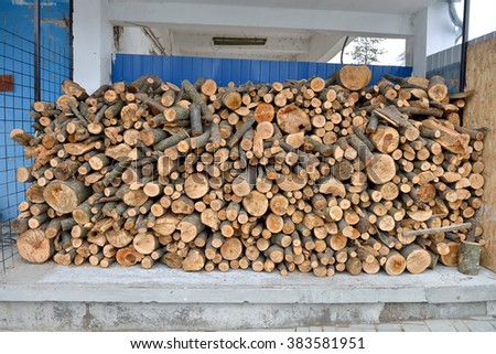 raw debarked wood logs in a lumber staging and storage yard. Raw timber stacked and ready to used in a car wash