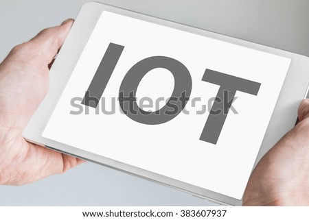 IOT (internet of things) text displayed on touchscreen of modern tablet or smart device. 