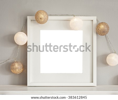 Image of a mockup scene with white frame and light baubles. 