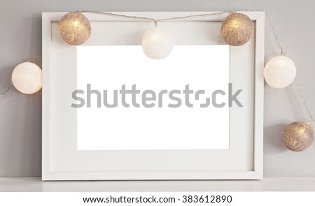 Image of a mockup scene with white landscape frame with baubles. 