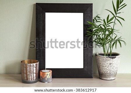 Image of frame mockup scene with plant and candle holders. 