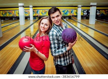 Beautiful girl and young man at the bowling alley with the ball