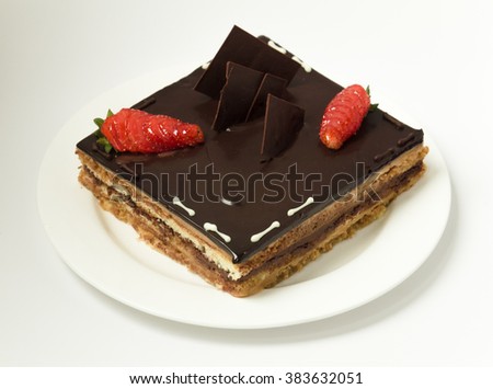 Decorated square cake with dark chocolate and strawberies, isolated on white plate