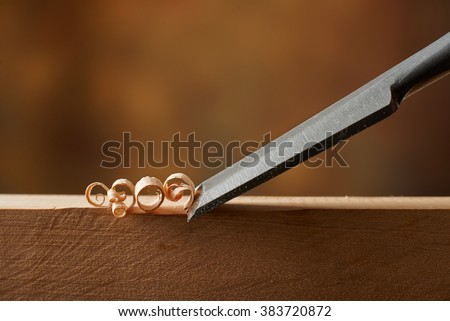 Woodworking tool. Carving wood with a chisel Royalty-Free Stock Photo #383720872