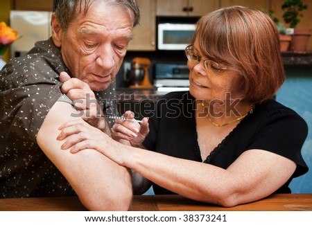 Senior woman giving man shot with small hypodermic needle Royalty-Free Stock Photo #38373241