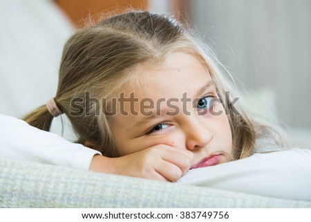 Frustrated little girl with ponytailes bored at home