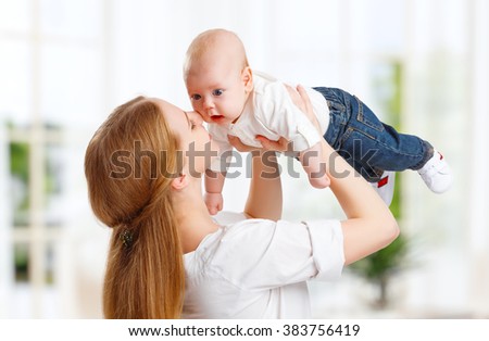 happy family playing mother  throws up child baby at home