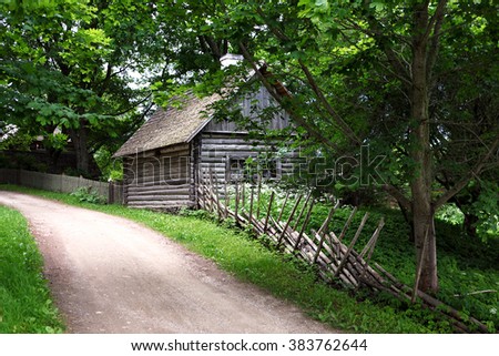 Rural landscape in Estonia. The wooden house, dirt road and a typical traditional fence. . Baltic States