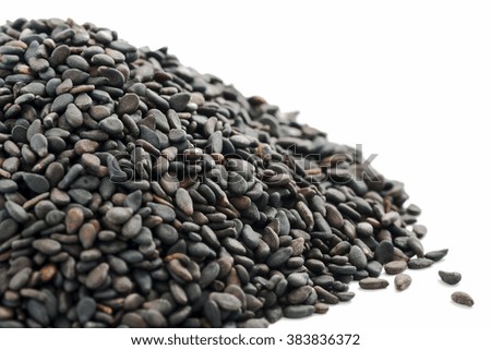 Macro close-up of black sesame seeds with selective focus on a white background.