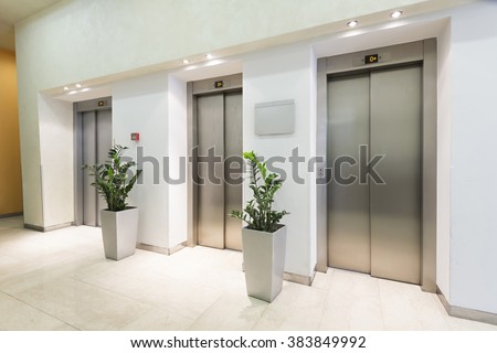 Three elevators in hotel lobby Royalty-Free Stock Photo #383849992