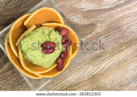 green tea icecream enrich with pancake in glass cup on wooden backgroud Royalty-Free Stock Photo #383852305