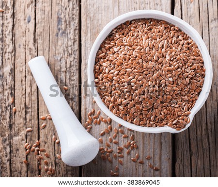  Seeds of the flax in a white porcelain bowl on wooden background.selective focus.