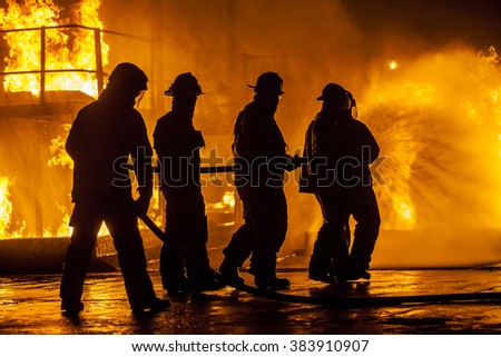 Firefighters hosing down fire