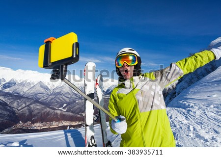 Happy screaming skier take photo with camera