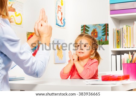 Girl playing finger games with teacher
