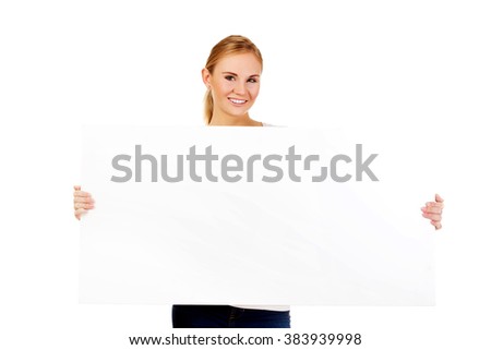 Happy young woman with blank billboard
