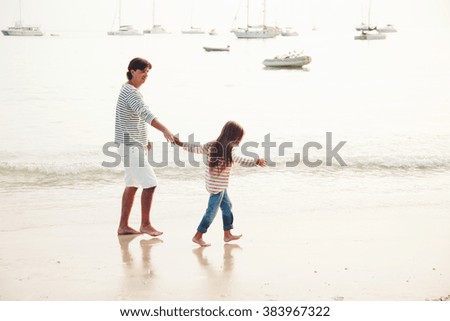 Family walking on the evening beach during sunset, travel photo series.