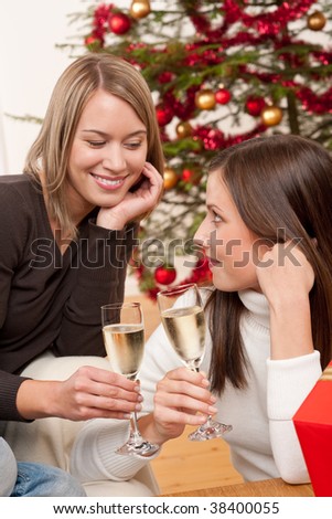 Two young women toasting with Champagne on Christmas