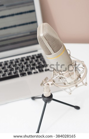 Microphone and a computer on a table in a studio. Sound recording theme image