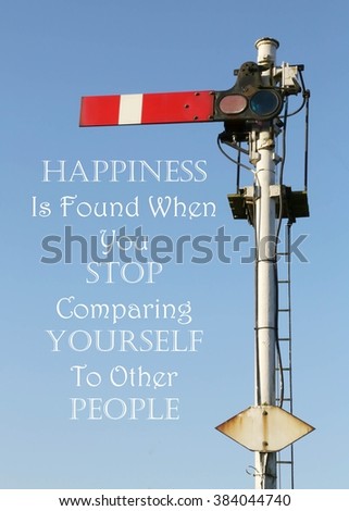 Historic red home British railway signal with an Inspirational motivational quote of Happiness Is Found When You Stop Comparing Yourself To Other People against a clear blue sky background.