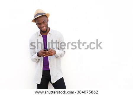 Portrait of a handsome young african man reading text message on mobile phone against white background