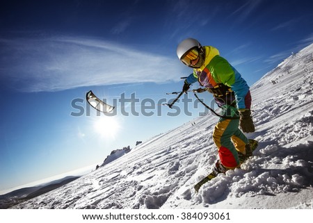 Happy snowboarder with kite lies in snowdrift. Sheregesh resort, Siberia, Russia Royalty-Free Stock Photo #384093061