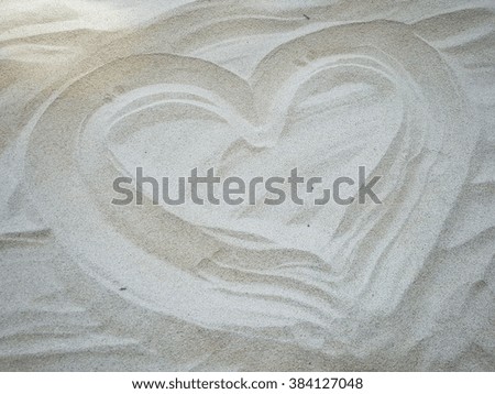 Draw a heart on the sand.