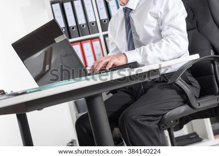Businessman sitting at his desk and working on laptop