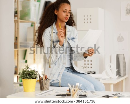 Shot of a yound designer sitting on a desk in her office