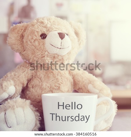 Hello Thursday coffee cup,focused on toy bear face in Blurred background with vintage filter