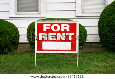 FOR RENT sign with house behind it, copy space on sign