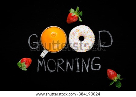 Good morning greeting written on black chalk board. Donut (doughnut), sweet orange and strawberries. Breakfast concept. Flat lay