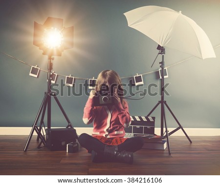 A photo of a vintage child taking a picture with an old camera in a studio with lights and film for a creativity or vision concept.