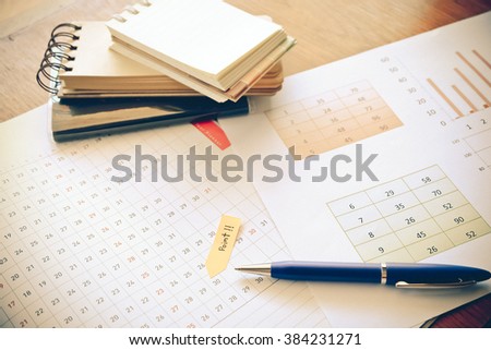 graph and note book on the wooden table with vintage color concept
