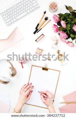 The female hands writing against fashion woman objects