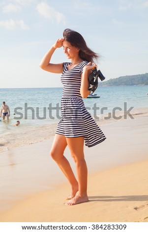 girl in a striped dress waiting by the sea